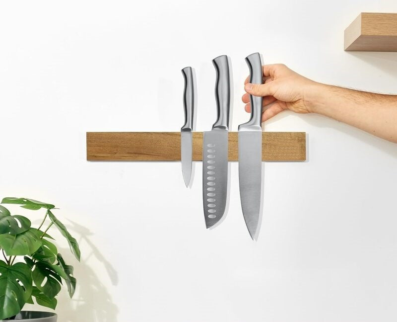 Bladora knife strip mounted on a kitchen wall holding three knives