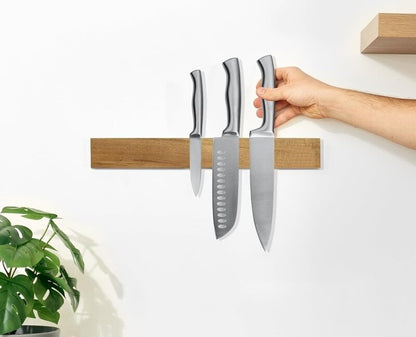 Bladora knife strip mounted on a kitchen wall holding three knives