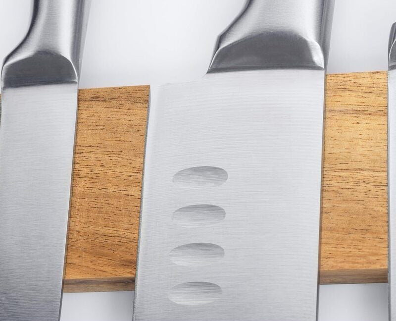 Close-up of a knife blade held against the acacia strip