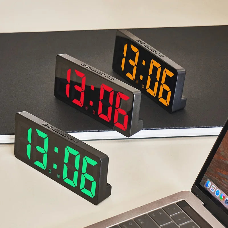 Three Reflexa clocks on a desk beside a laptop