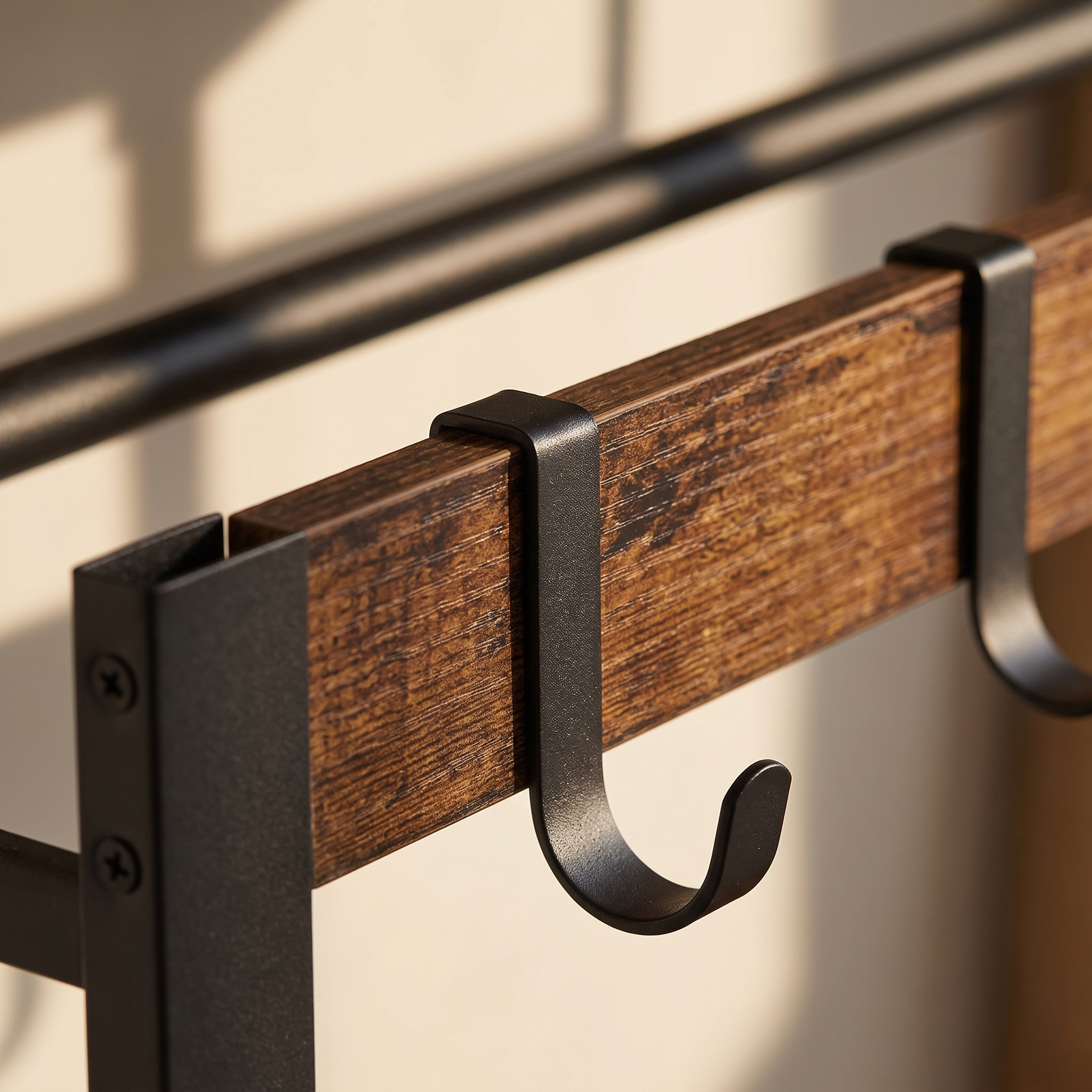 Close-up of the black sliding hooks and rustic wood slat of the Arvid coat rack