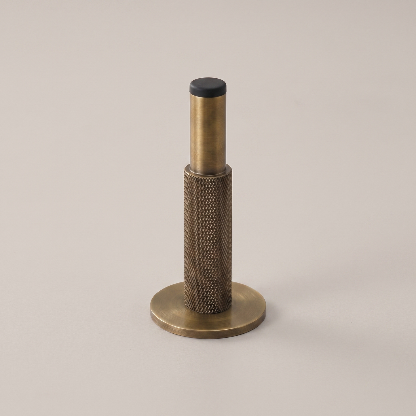 Knurlia solid brass knurled door stop - studio packshot, antique brass