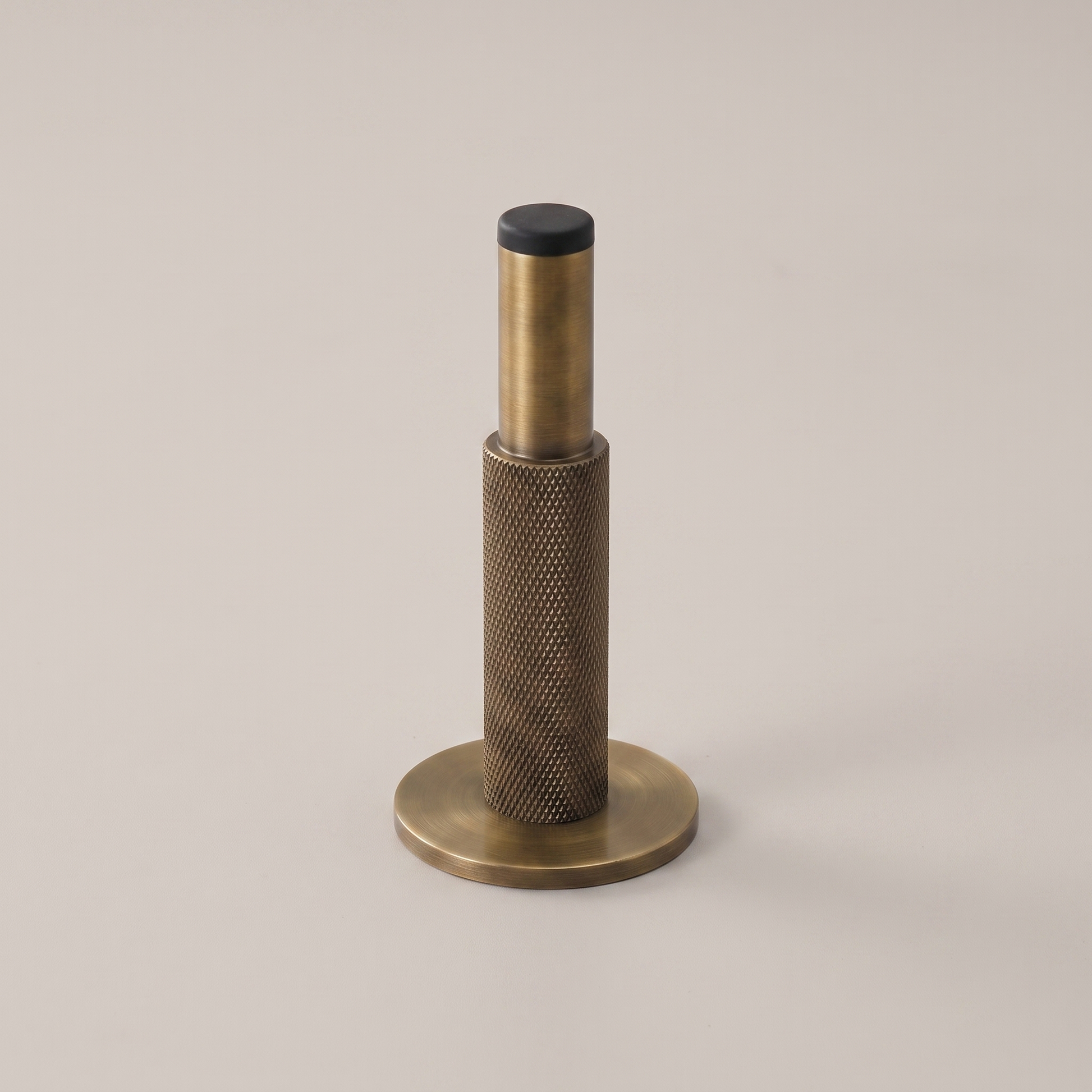 Knurlia solid brass knurled door stop - studio packshot, antique brass