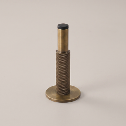 Knurlia solid brass knurled door stop - studio packshot, antique brass